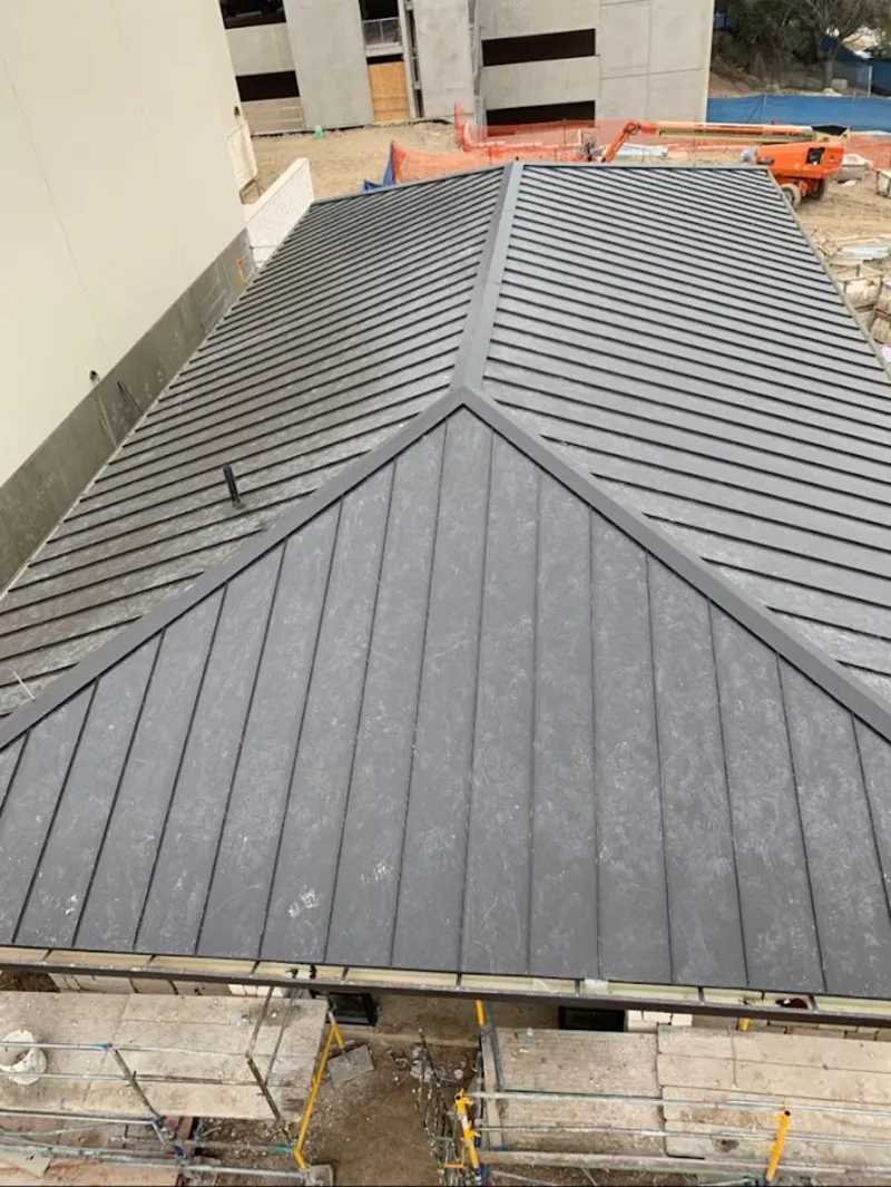 Commercial metal roof construction with crane equipment in South Brunswick